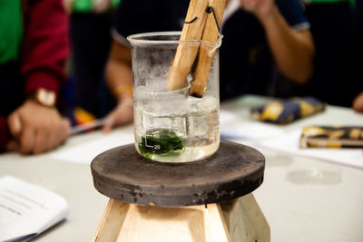 Midsection of person drinking glass on table