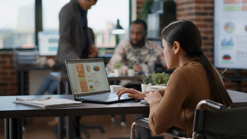 Young woman using laptop at table