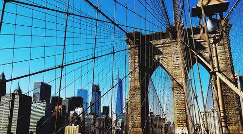 Low angle view of suspension bridge against blue sky