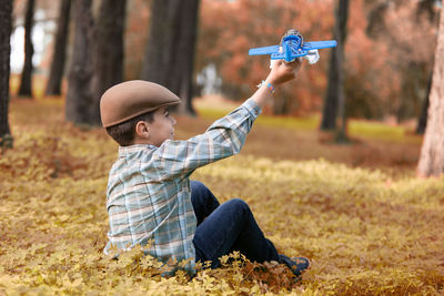Boy holding umbrella on field