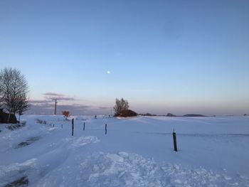 Scenic view of snow covered field against sky