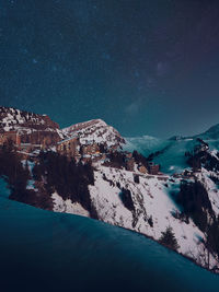 Scenic view of snowcapped mountains against sky at night