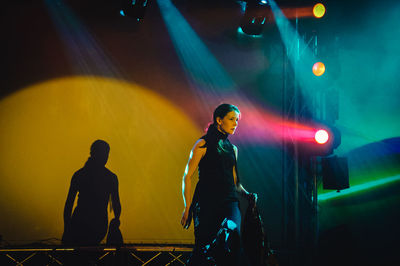 Women standing on illuminated stage