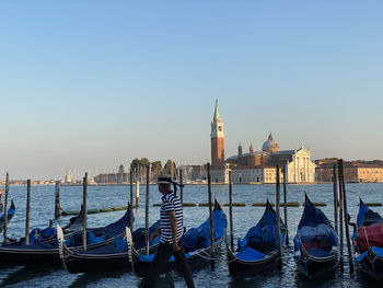 Boats moored at canal against sky