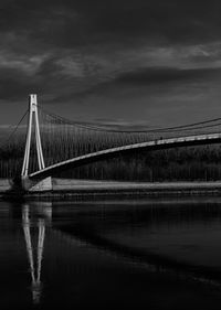 Bridge over river against cloudy sky