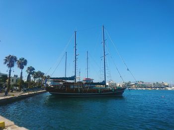 Sailboats sailing in sea against clear blue sky