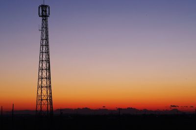 Silhouette crane against sky during sunset