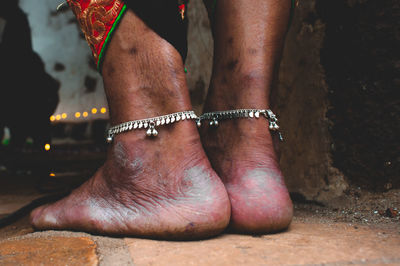 Low section of woman wearing anklet outdoors