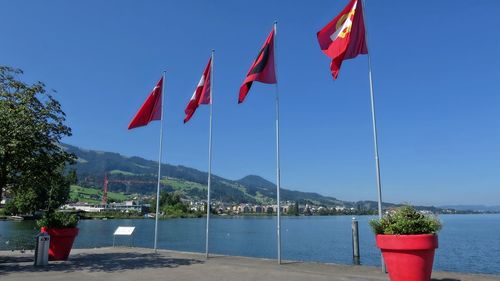 Red flags on mountain against sky