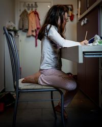 Rear view of girl standing at home