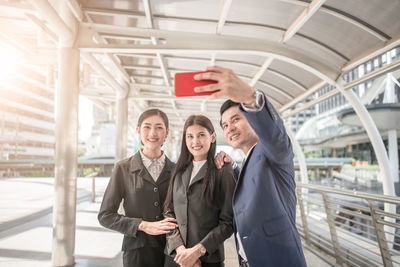 Business colleagues taking selfie with smart phone in city