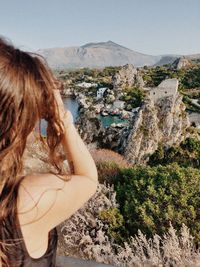 Rear view of woman standing against mountain