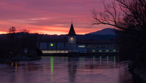 Buildings at waterfront during sunset