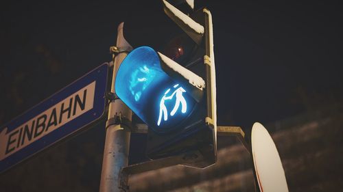 Low angle view of road sign at night