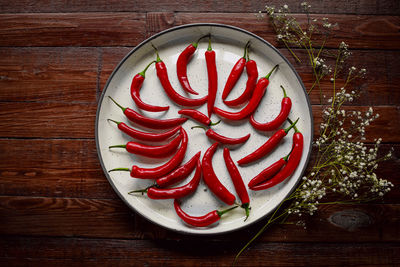 Red hot chilli peppers in a white tray on wooden background. spicy.