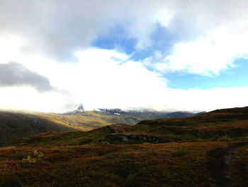 Scenic view of mountains against cloudy sky