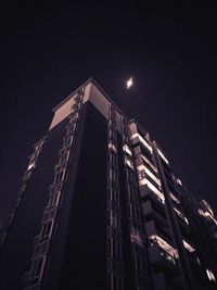 Low angle view of illuminated buildings against sky at night