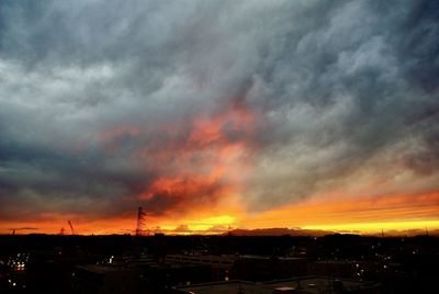 Scenic view of dramatic sky over city during sunset