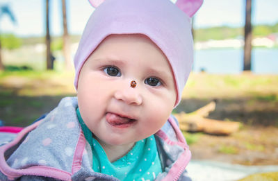 Portrait of baby with ladybug on nose