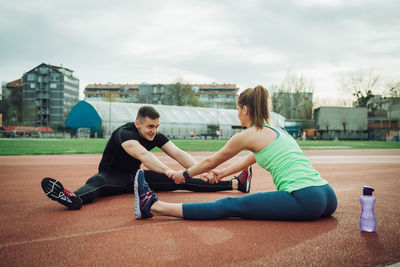 Friends exercising together on sports track