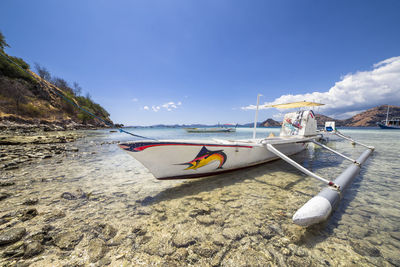 Boat moored on beach against sky, komodo indonesia 