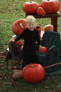 Full length of boy holding pumpkin on field