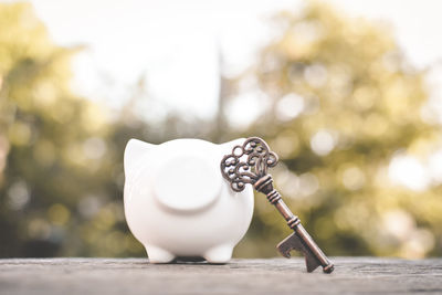 Close-up of piggy bank with key on table