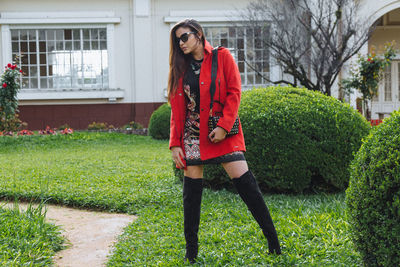 Full length of woman standing against house in yard