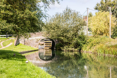 Built structure by lake against trees