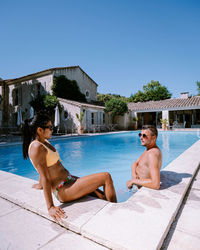 Full length of shirtless man in swimming pool against sky