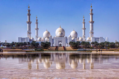 Reflection of building in water against clear sky