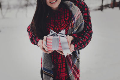 Boyfriend giving a gift box present with ribbon outdoor due to saint valentine day to her girlfriend