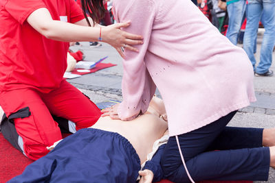 Midsection of women giving cpr on dummy