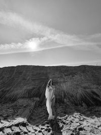 Woman standing on land against sky