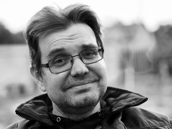 Black and white portrait of a friendly unshaven caucasian man with glasses