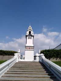 Low angle view of lighthouse by building against sky