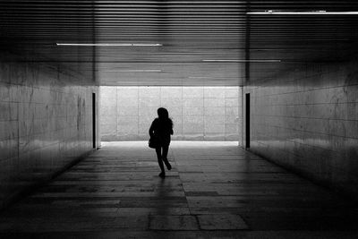 Rear view of woman walking in corridor