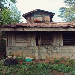 Old house by building against sky