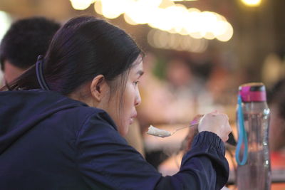 Portrait of woman drinking water from bottle