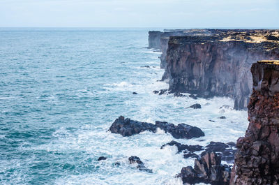 Scenic view of rocks in sea against sky