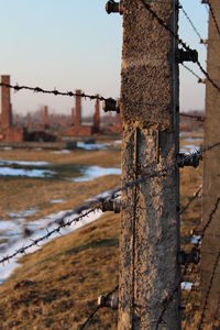 Close-up of rusty metal fence by canal