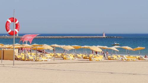 Umbrellas on beach against clear sky