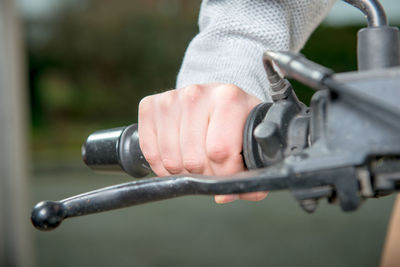 Close-up of hand holding bicycle