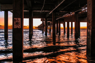 Pier over sea against sky during sunset