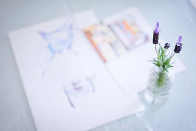 High angle view of vase and papers on table