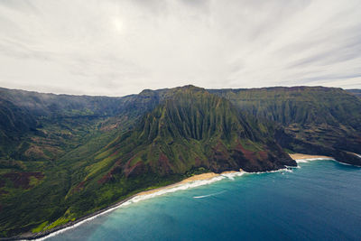 Scenic view of sea and mountains against sky napali coast kauai