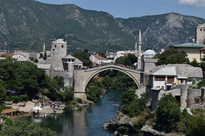 Arch bridge over river amidst buildings