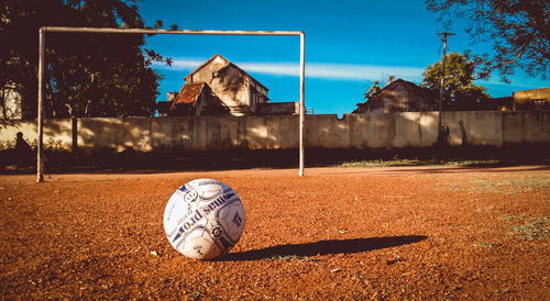 Soccer ball on field against sky