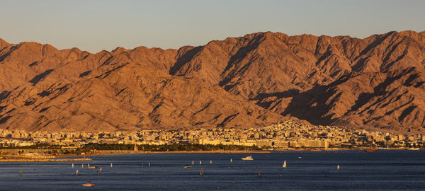 Scenic view of lake and mountains against clear sky