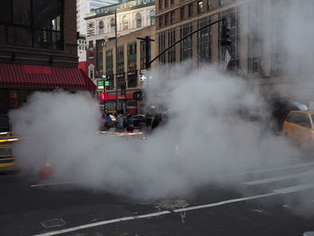 Smoke on city street against buildings